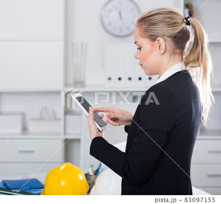 Businesswoman using phone in design office 83097155