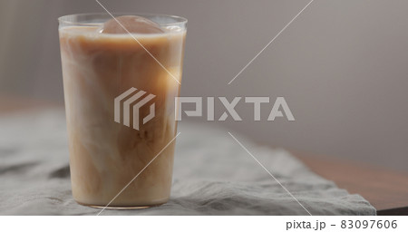 milk pour cold in brew coffee in tumbler glass on walnut table 83097606