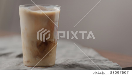 milk pour cold in brew coffee in tumbler glass on walnut table 83097607