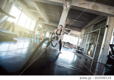 Muscular asian women exercise with rope in fitness gym Muscular asian women exercise with rope in fitness gym 83098529