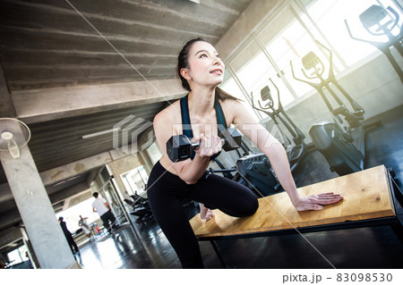 Sport asian women lifting dumbbell in gym 83098530