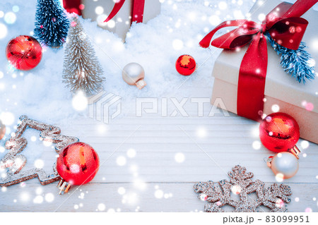 Table wood Christmas. Xmas board with old rustic wall, white frozen snow, golden balls and gift box. Winter wooden decoration background. Happy new year copy space. 83099951
