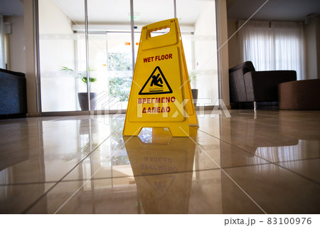 Yellow sign warning about wet floor. The inscription in the Greek language "wet floor" Yellow sign warning about wet floor. The inscription in the Greek language "wet floor" 83100976