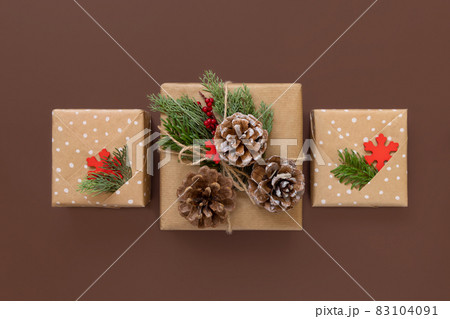 Wrapped Christmas present on brown background top view Wrapped Christmas present on brown background top view 83104091