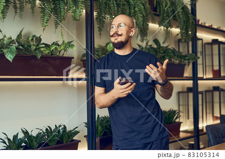 businessman trader holds his smartphone in a hand talking on headphones. Good deals. Profits.  businessman trader holds his smartphone in a hand talking on headphones. Good deals. Profits.  83105314