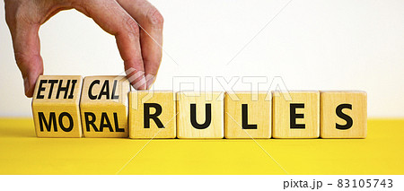 Ethical or moral rules symbol. Businessman turns wooden cubes and changes words 'ethical rules' to 'moral rules' on a beautiful white background. Business, ethical or moral rules concept. Copy space. 83105743