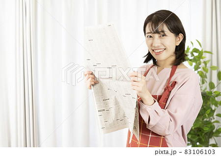 新聞の株式欄を読む女性 83106103