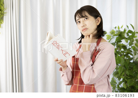 リビングで投資の本を読む女性 83106193