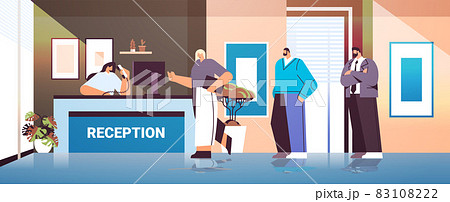 business people customers or travelers standing at reception desk and talking to receptionist 83108222