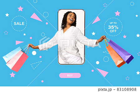 Positive black lady with shopper bags coming out of mobile phone screen, feeling excited over big sale, shopping online 83108908