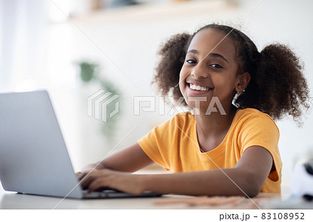 Cheerful black girl studying online, using laptop, typing on keyboard 83108952