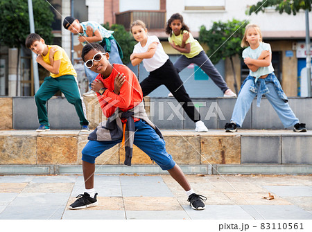 Preteen boys and girls breakdancers dancing on city street 83110561