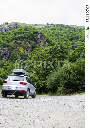 car for traveling with a roof rack on a mountain road 83110703
