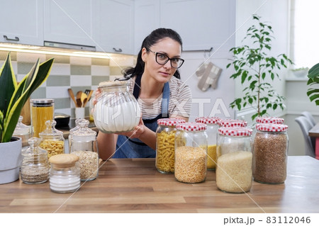 Food, grocery storage, smiling woman looking at the camera in the kitchen. Food, grocery storage, smiling woman looking at the camera in the kitchen. 83112046