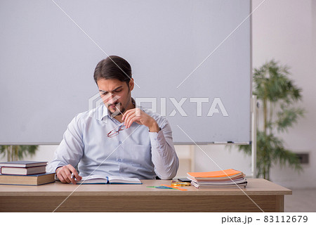 Young male teacher in front of whiteboard Young male teacher in front of whiteboard 83112679
