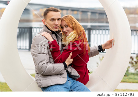 young couple in the autumn park sitting on a swing young couple in the autumn park sitting on a swing 83112793