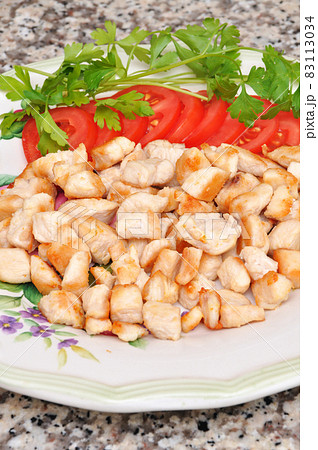 Fresh and fried chicken meat breast pieces, ready to cook, with tomato and parsley Fresh and fried chicken meat breast pieces, ready to cook, with tomato and parsley 83113034