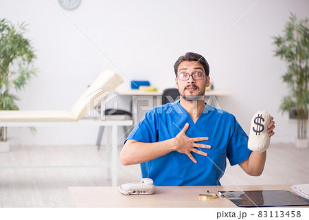 Young male doctor in remuneration concept Young male doctor in remuneration concept 83113458