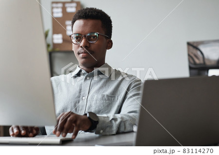 Young African American Man Using Computer at Work Young African American Man Using Computer at Work 83114270