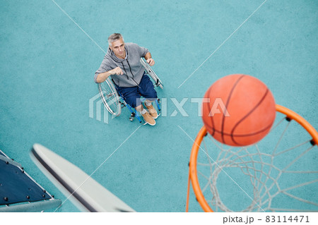 Man throwing the ball into the basket 83114471
