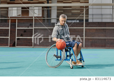Man with disability playing basketball outdoors 83114673
