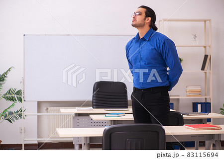 Young male teacher in front of whiteboard 83115694