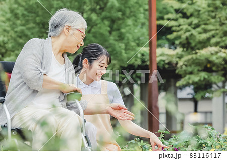 車椅子に乗った高齢者女性と女性スタッフ(花畑) 車椅子に乗った高齢者女性と女性スタッフ(花畑) 83116417