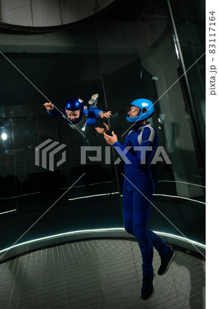 A man teaches a boy to fly in a wind tunnel. Lack of gravity. 83117164