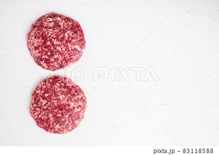 Patty of minced meat for burger, on white stone background, top view flat lay, with copy space for text Patty of minced meat for burger, on white stone background, top view flat lay, with copy space for text 83118588