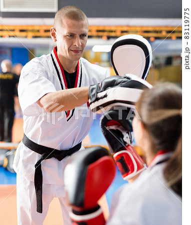 Woman launching blows on focus punch mitts Woman launching blows on focus punch mitts 83119775
