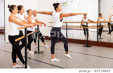 Female ballet teacher showing dancers how to dance ballet in studio Female ballet teacher showing dancers how to dance ballet in studio 83119802