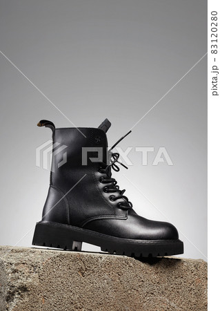 Black boot on a cinder block. fashion shoes still life Black boot on a cinder block. fashion shoes still life 83120280