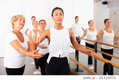 Women training ballet moves with trainer 83120435
