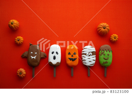 Set of ice cream with halloween character face with pumpkins on orange background. Halloween party background. 83123100