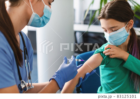 Teen Girl Receiving Vaccine Injection In Arm In Medical Centre 83125101