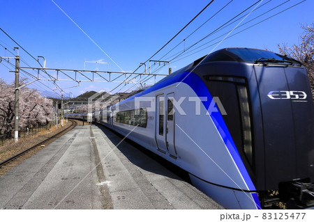 桜満開の勝沼ぶどう郷駅で通過する特急あずさ 83125477