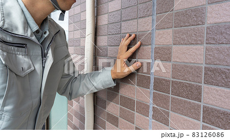 外壁を点検する作業員。目地の劣化。 83126086