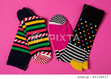 two pairs of unisex socks with color pattern, on pink background, concept 83126417