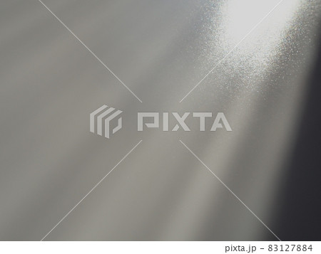 Diagonal rays of light on a gray background. Blurred abstract background light effect, light leaks. Side surface illumination. Small sparks and glow. Shine, glint or glare. Right top left down 83127884