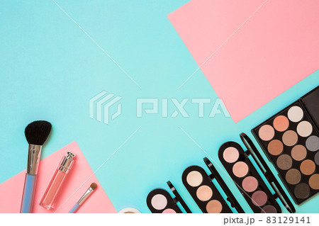 Make up essentials. Set of professional make up brushes, creams and shadows in jars on blue background. Make up essentials. Set of professional make up brushes, creams and shadows in jars on blue background. 83129141