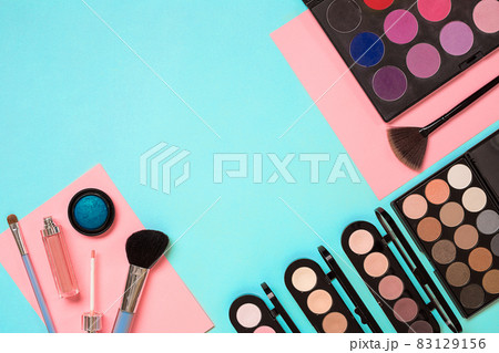 Make up essentials. Set of professional make up brushes, creams and shadows in jars on blue background. 83129156