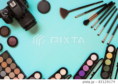 Make up essentials. Set of professional make up brushes, creams and shadows in jars on blue background. Make up essentials. Set of professional make up brushes, creams and shadows in jars on blue background. 83129174