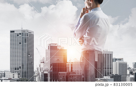 Concept of business success and control with confident boss against cityscape background Concept of business success and control with confident boss against cityscape background 83130005