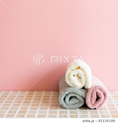 Bathroom towel on mosaic tile table. pink wall background. Skin care and spa concept. Home interior 83130199