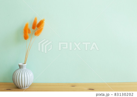 Vase of orange hares tail grass dry flowers on wooden table. mint wall background. copy space Vase of orange hares tail grass dry flowers on wooden table. mint wall background. copy space 83130202