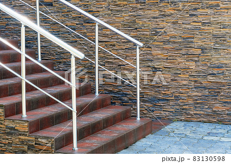 modern staircase with handrails and steps to the entrance to the building, decorative stone wall and lantern modern staircase with handrails and steps to the entrance to the building, decorative stone wall and lantern 83130598