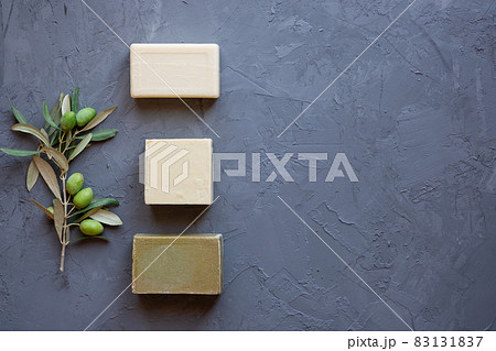 Handmade soap bars and olive branch on grey background, beauty treatment ,top view copy space. 83131837