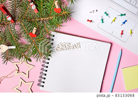 Christmas composition of open blank notepad, fir branches and laptop on pink paper background 83133068