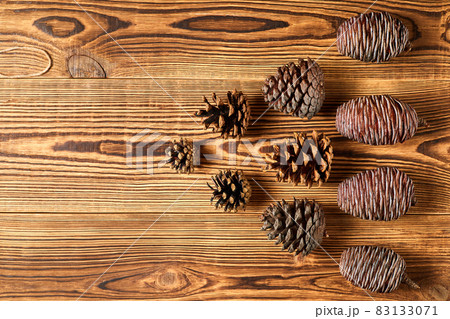 Fir cones on brown wooden background with copy space 83133071