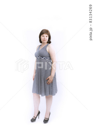 Plus size model in gray medium-length with heels. Isolated on white background. Plus size model in gray medium-length with heels. Isolated on white background. 83134269